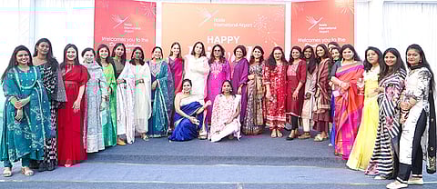 Women workers from various departments pose for a photograph at the upcoming Noida International Airport in Noida, Uttar Pradesh. 