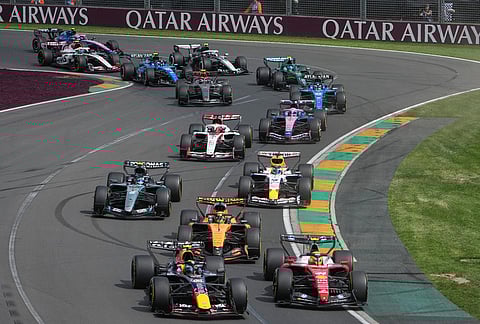 Red Bull driver Isack Hadjar, left, of France and Ferrari driver Lewis Hamilton of Britain steer their cars out of turn two at the start of the Australian Formula One Grand Prix at Albert Park, in Melbourne, Australia.