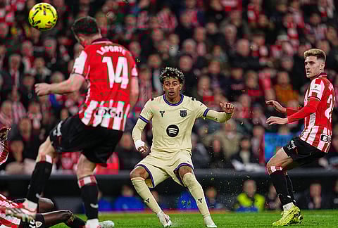 Barcelona's Lamine Yamal, center, scores his side's opening goal during the Spanish La Liga soccer match between Athletic Bilbao and Barcelona in Bilbao, Spain.