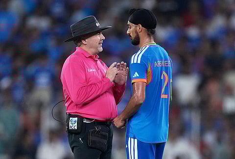 Umpire Richard Illingworth speaks with India's Arshdeep Singh after a misguided throw by the latter hit New Zealand's Daryl Mitchell's bat during the T20 World Cup cricket final match between India and New Zealand in Ahmedabad.