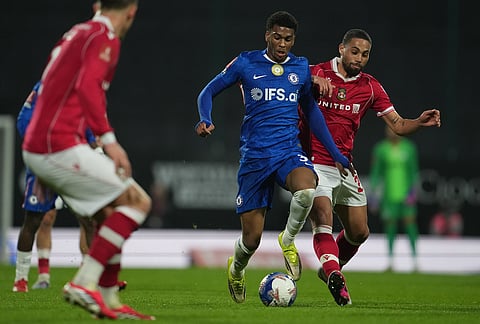 Chelsea's Josh Acheampong, left, and Wrexham's Zak Vyner fight for the ball during the fifth round FA Cup soccer match between Wrexham and Chelsea in Wrexham, Wales.