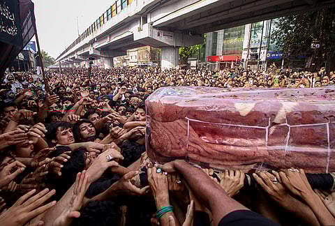 People carry a symbolic coffin during a procession marking the martyrdom anniversary of Imam Ali, in Lucknow.