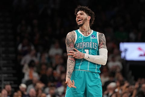 Charlotte Hornets guard LaMelo Ball reacts towards a fan after scoring against the Phoenix Suns during the second half of an NBA basketball game in Phoenix.
