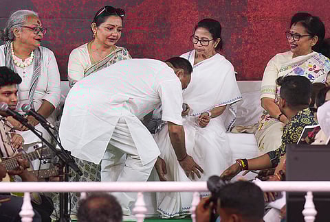 A Trinamool Congress leader seeks blessings from West Bengal Chief Minister Mamata Banerjee during a sit-in dharna on the fourth day of a protest against alleged arbitrary deletions from the post-SIR electoral rolls, in Kolkata.