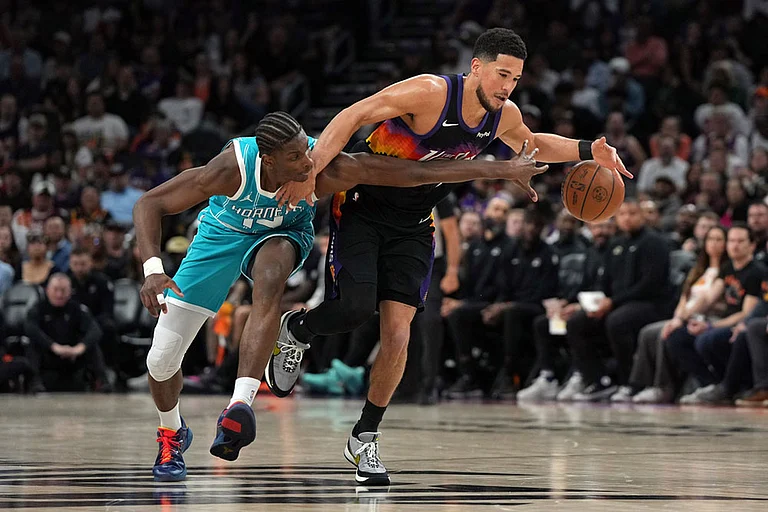 Charlotte Hornets forward Moussa Diabate (14) pressures Phoenix Suns guard Devin Booker during the second half of an NBA basketball game in Phoenix. - | Photo: AP/Rick Scuteri