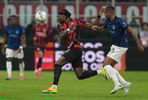 AC Milan's Rafael Leao, left, and Inter Milan's Manuel Akanji fight for the ball during the Serie A soccer match between AC Milan and Inter Milan, in Milan, Italy.