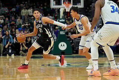Milwaukee Bucks' Ousmane Dieng (21) dribbles against Orlando Magic's Tristan da Silva during the first half of an NBA basketball game, in Milwaukee.