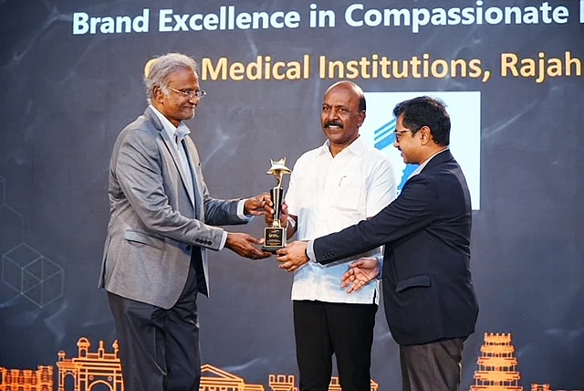 Dr. Ganni Bhaskara Rao receiving an award trophy on stage at a medical institutions event