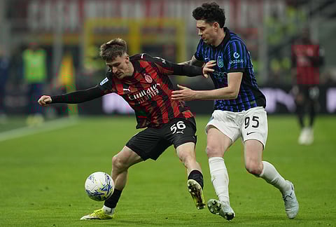 AC Milan's Alexis Saelemaekers, left, and Inter Milan's Alessandro Bastoni fight for the ball during the Serie A soccer match between AC Milan and Inter Milan, in Milan, Italy.