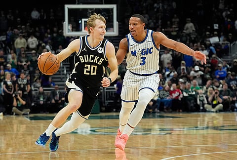 Milwaukee Bucks' AJ Green (20) drives to the basket against Orlando Magic's Desmond Bane during the first half of an NBA basketball game, in Milwaukee.