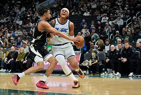 Orlando Magic's Paolo Banchero, right, drives to the basket against Milwaukee Bucks' Ousmane Dieng during the second half of an NBA basketball game in Milwaukee.