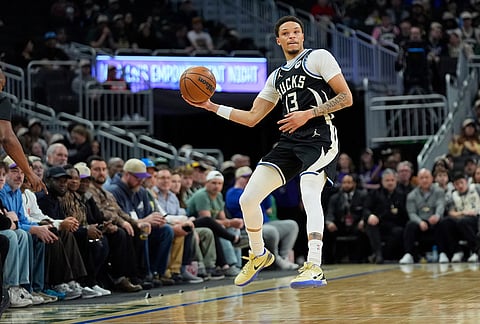 Milwaukee Bucks' Ryan Rollins attempts to save the ball after committing a backcourt violation during the first half of an NBA basketball game against the Orlando Magic, in Milwaukee.