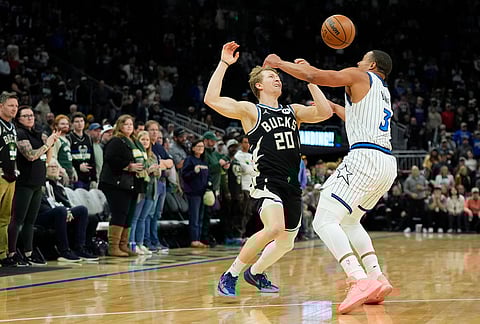 Milwaukee Bucks' AJ Green (20) loses control of the ball against Orlando Magic's Desmond Bane during the first half of an NBA basketball game in Milwaukee.