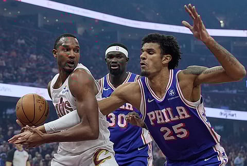 Philadelphia 76ers forward Dominick Barlow (25) reaches in to knock the ball away from Cleveland Cavaliers center Evan Mobley, left, in the first half of an NBA basketball game in Cleveland.