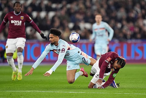 West Ham United's Kyle Walker-Peters, right, and Brentford's Kevin Schade in action during the English FA Cup fifth round soccer match between West Ham United and Brentford in London.