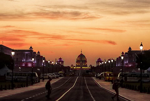 A view of Rashtrapati Bhavan at sunset with orange clouds in the sky, in New Delhi.