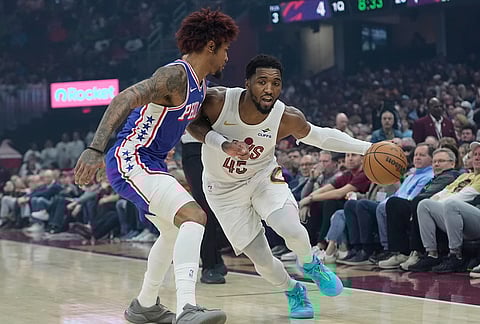 Cleveland Cavaliers guard Donovan Mitchell (45) drives around Philadelphia 76ers guard Kelly Oubre Jr., left, in the first half of an NBA basketball game in Cleveland.