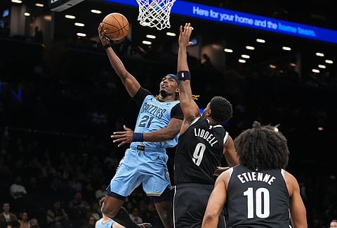Memphis Grizzlies' Jahmai Mashack (21) drives past Brooklyn Nets' E.J. Liddell (9) and Tyson Etienne (10) during the second half of an NBA basketball game in New York.