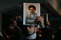 
Iraqis hold a portrait of the new successor to Supreme Leader, Ayatollah Mojtaba Khamenei at a bridge leading to the fortified Green Zone where the U.S. embassy is located in Baghdad, Iraq, Monday, March 9, 2026. 