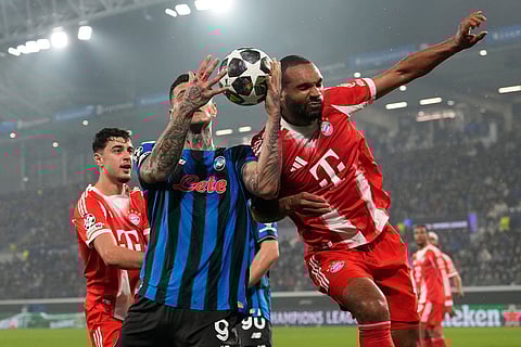 Atalanta's Gianluca Scamacca, left, and Bayern's Jonathan Tah challenge for the ball during the Champions League round of 16 soccer match between Atalanta and FC Bayern Munich in Bergamo, Italy.