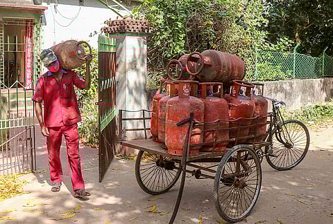 A delhivery person carries a used LPG cylinders from a residence in Bolpur, Birbhum district of West Bengal, Tuesday, March 10, 2026. 