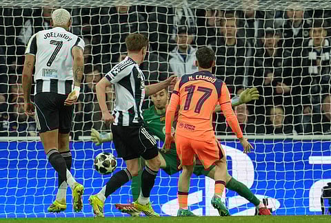 Newcastle's Harvey Barnes, center, scores the opening goal during the Champions League round of 16 first leg soccer match between Newcastle United and Barcelona in Newcastle, England.