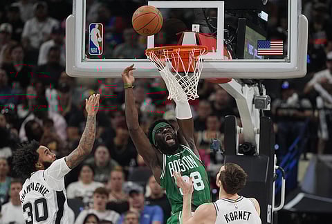 Boston Celtics center Neemias Queta (88) is fouled as he tries to score past San Antonio Spurs center Luke Kornet (7) and forward Julian Champagnie (30) during the second half of an NBA basketball game in San Antonio.