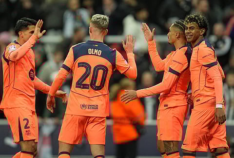 Barcelona's Lamine Yamal, right, celebrates with Raphinha and Dani Olmo after scoring his side's first goal during the Champions League round of 16 first leg soccer match between Newcastle United and Barcelona in Newcastle, England.
