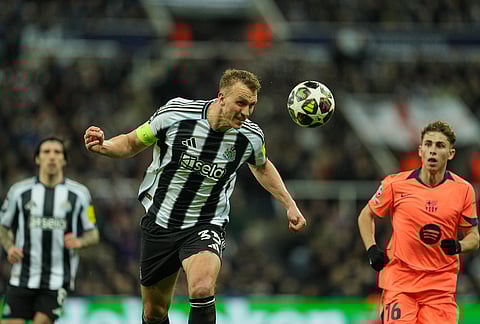Newcastle's Dan Burn clears the ball during the Champions League round of 16 first leg soccer match between Newcastle United and Barcelona in Newcastl, England.