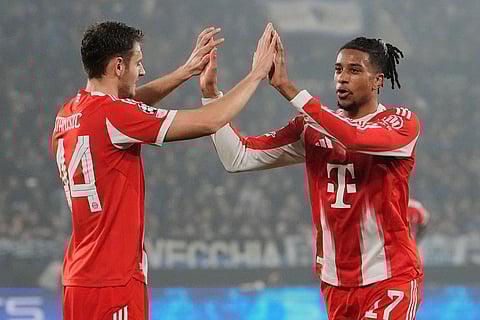 Bayern's Michael Olise, right, celebrates after scoring his side's fourth goal with Josip Stanisic during the Champions League round of 16 soccer match between Atalanta and FC Bayern Munich in Bergamo, Italy.
