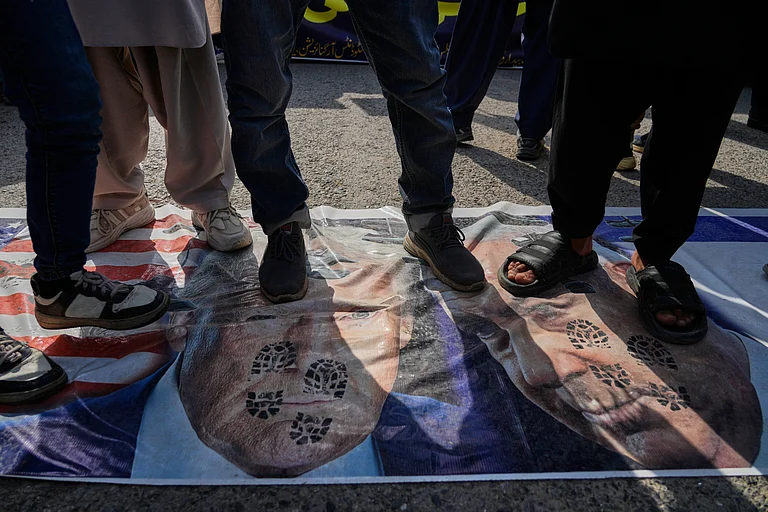 Shiite Muslims stands over the representation of U.S. and Israeli flags with pictures of President Donald Trump and Prime Minister Benjamin Netanyahu during a rally to condemn the killing of Iranian Supreme Leader Ayatollah Ali Khamenei and against the Israeli strikes on Iran - AP