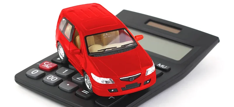 Red car model placed on a calculator