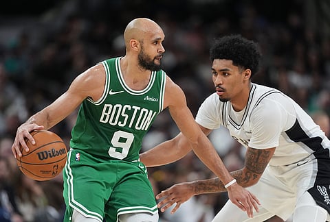 Boston Celtics guard Derrick White (9) works the ball against San Antonio Spurs guard Dylan Harper (2) during the second half of an NBA basketball game in San Antonio.
