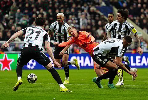 Newcastle United's Malick Thiaw, right, fouls Barcelona's Dani Olmo which results in a penalty kick during the Champions League round of 16 first leg soccer match between Newcastle United and Barcelona in Newcastle, England.