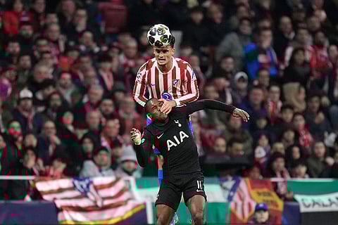 Atletico Madrid's Marc Pubill, top, and Tottenham's Mathys Tel challenge for the ball during the first leg of the Champions League round of 16 soccer match between Atletico Madrid and Tottenham in Madrid, Spain.