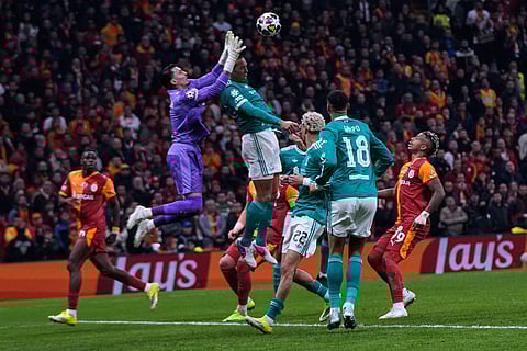 Liverpool's Virgil van Dijk, top right, and Galatasaray's goalkeeper Ugurcan Cakir fight for a high ball during a Champions League round of 16 first leg soccer match between Galatasaray and Liverpool, in Istanbul, Turkey.