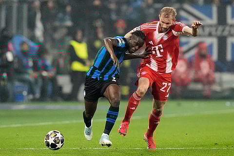 Atalanta's Kamaldeen Sulemana, left, and Bayern's Konrad Laimer challenge for the ball during the Champions League round of 16 soccer match between Atalanta and FC Bayern Munich in Bergamo, Italy.