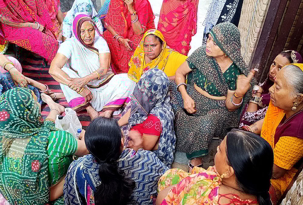 Tarun Kumar’s mother, Sunita, sitting outside her home in Uttam Nagar, Delhi, surrounded by women who had come to comfort her after her son’s alleged killing. - | Photo: Suresh K Pandey/Outlook