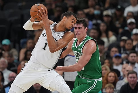 San Antonio Spurs forward Victor Wembanyama (1) drives against Boston Celtics center Luka Garza (52) during the first half of an NBA basketball game in San Antonio.