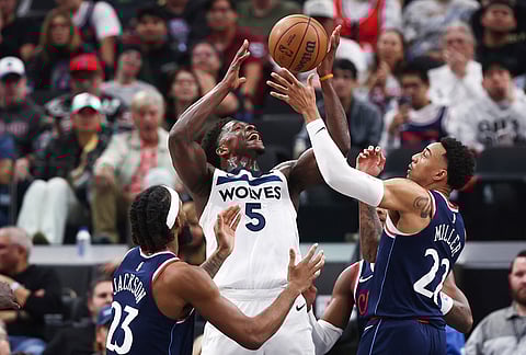 Minnesota Timberwolves guard Anthony Edwards (5) draws a foul against Los Angeles Clippers forward Isaiah Jackson (23) and guard Jordan Miller (22) during the first half of an NBA basketball game, in Inglewood, California.