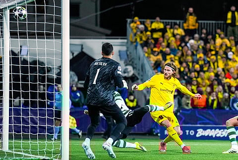 Bodo/Glimt's Kasper Hogh, right, scores their side's third goal of the game during the Champions League soccer match between Bodo/Glimt and Sporting Lisbon, in Bodo, Norway.