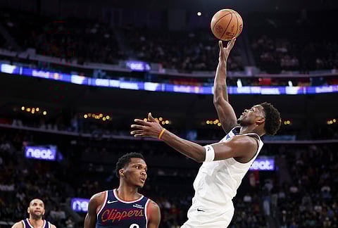 Minnesota Timberwolves guard Anthony Edwards, right, shoots as Los Angeles Clippers guard Bennedict Mathurin, center, and forward Nicolas Batum, back left, watch during the second half of an NBA basketball game, in Inglewood, California. 