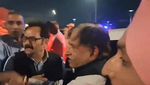 Kamal Singh Jamwal, center, who allegedly fired a shot targeting National Conference president Farooq Abdullah and Jammu and Kashmir Deputy Chief Minister Surinder Choudhary at a wedding function, being detained by people before being handed over to security personnel, in Jammu, Wednesday, March 11, 2026.