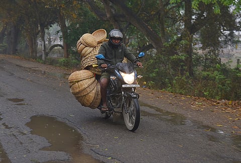 A vendor carries bamboo products to sell amid rainfall, at Baganpara, in Baksa district, Assam. The area saw partly cloudy sky with a spell of light rainfall. 