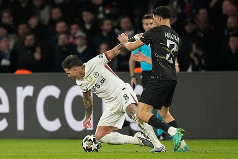 Chelsea's Enzo Fernandez, left, and PSG's Achraf Hakimi challenge for the ball during the first leg of the Champions League round of 16 soccer match between Paris Saint-Germain and Chelsea, in Paris.