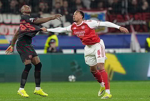 Arsenal's Gabriel, right, holds Leverkusen's Christian Kofane during the Champions League round of 16 first leg soccer match between Bayer Leverkusen and Arsenal FC in Leverkusen, Germany.