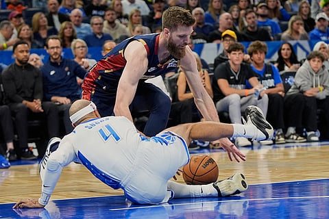 Orlando Magic guard Jalen Suggs (4) and Cleveland Cavaliers forward Dean Wade go after a loose ball during the first half of an NBA basketball game in Orlando, Fla.
