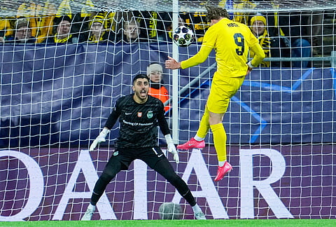 Bodo/Glimt's Kasper Hogh heads the ball as he tries to score against Sporting goalkeeper Rui Silva during the Champions League soccer match between Bodo/Glimt and Sporting Lisbon, in Bodo, Norway.