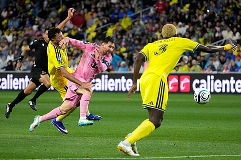 Inter Miami forward Lionel Messi, center, chases the ball as he is defended by Nashville SC midfielder Patrick Yazbek, left, and defender Maxwell Woledzi (3) in the first half of a CONCACAF Champions Cup Round of 16 soccer match  in Nashville, Tenn.