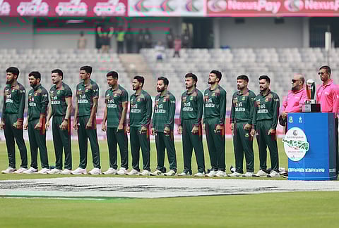 Bangladesh's players stand up for their national anthem before the start of the first one day international cricket match between Bangladesh and Pakistan in Mirpur, Bangladesh.